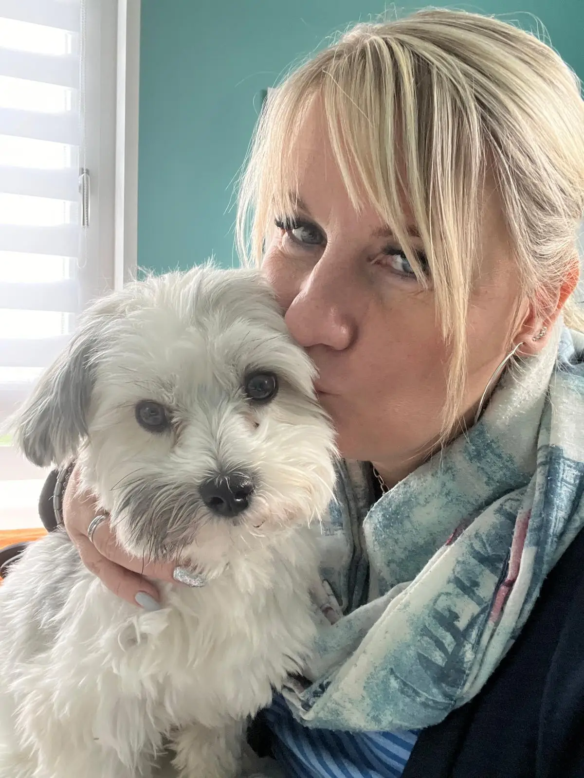 Katrin Caldewei gibt ihrem weißen Hund Sammy einen Kuss auf den Kopf